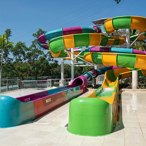 Dos toboganes acuáticos, uno verde con rayas amarillas y el otro azul con rayas púrpuras, que se pueden encontrar en las reservas del fin de semana del hotel Lagomar